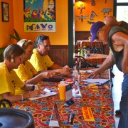 people sitting behind a registration table in Fat Mama's restaurant - Fat Mama's Tamales Krewe | Fat Mama's Tamales