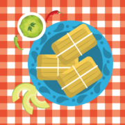 red and white tablecloth with plate of tamales with sauce